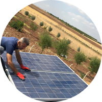 A man adjusts a solar panel in a field.