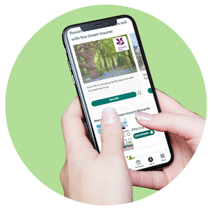 User holding a phone with the The Green Insurer app on a light green background.