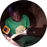 Child reading at night with their solar light.