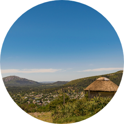 A scenic view of a mountain range with a small hut nestled in the foreground.