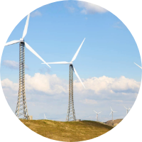 Wind turbines standing tall in a green field.